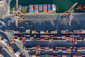 Aerial view of international port with crane loading containers.